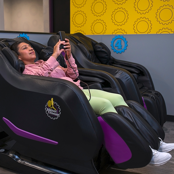  mujer disfrutando de un sillón de masaje